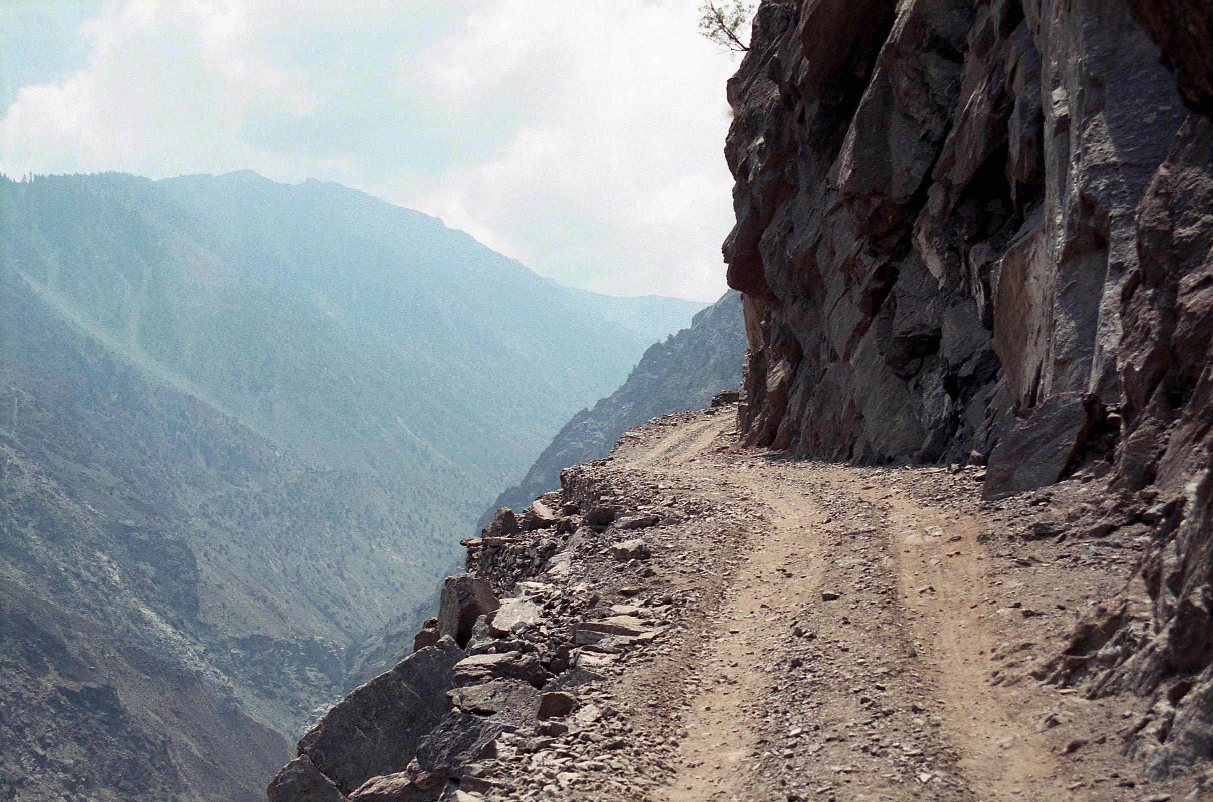 03 Dangerous Jeep Road Towards Fairy Meadows On the 15km jeep ride from the Rakhiot Bridge to Tato, I can look over the edge of the road on the way to Fairy Meadows at the sheer drop of 1000m and think about, well, death.  I especially feared if we would meet another jeep, but we didn't. I watch the local driver and hope he had a good night's sleep and is in a good mood. My life is clearly in his hands and feet. After a drive of one hour we arrived at the small village of Tato (2300m).